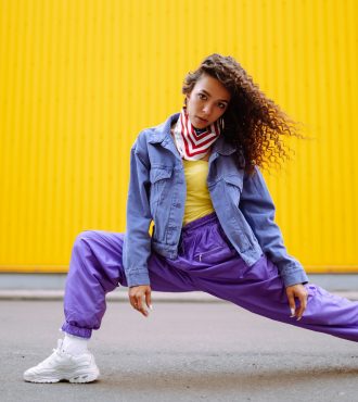 Funky young woman with american bandana dancing alone in the street.Sport, dancing and urban culture